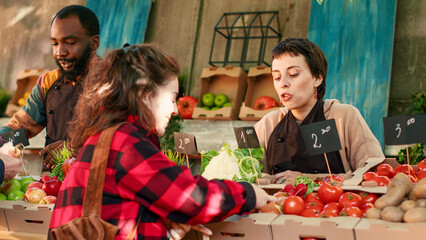 Smiling consumer buying fresh organic eco veggies at farmers market counter, happy customer holding box with natural vegetables. Person buying various farm produce, food market. Handheld shot.