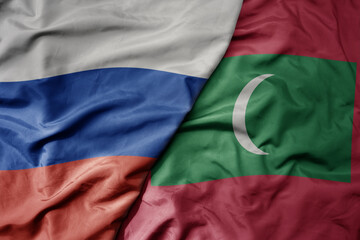 big waving realistic national colorful flag of russia and national flag of maldives .