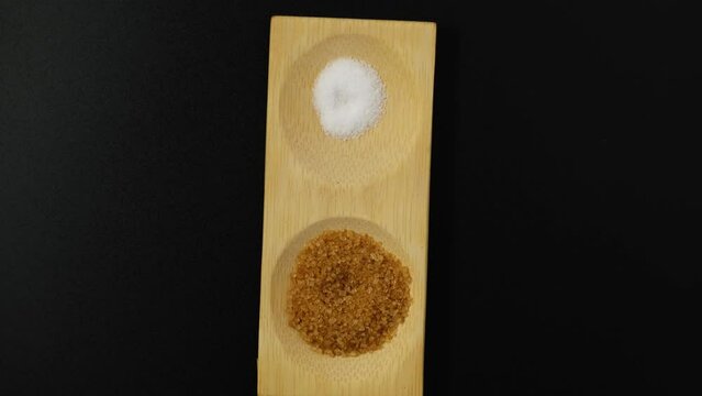 Comparison of brown cane natural sugar and artificial sweetener or sugar substitute. Video 4K, Rotating.