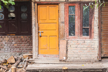 Fototapeta na wymiar Yellow door in a brick house in Srinagar.