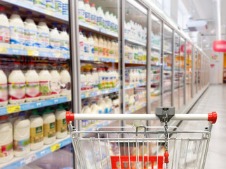 Choosing food from shelf in supermarket,vegetables in grocery section,empty grocery cart in an empty supermarket