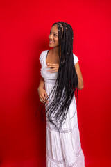 Portrait of young, beautiful woman, standing, messing with her hair braids.