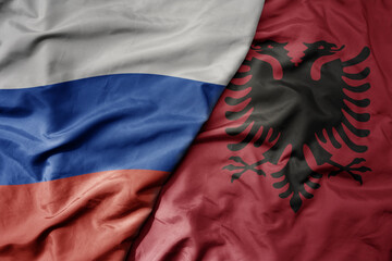 big waving realistic national colorful flag of russia and national flag of albania .