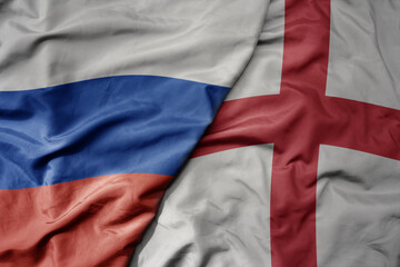 big waving realistic national colorful flag of russia and national flag of england .