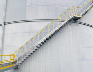 A long iron ladder is next to the palm oil storage tank.
