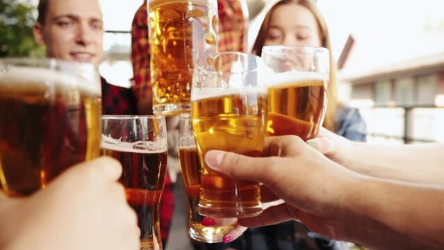 Group of cheerful young people, friends meeting at cafe, pub, spending time together, drinking beer. Celebration and fun. Concept pktoberfest, traditional taste, friendship, leisure time, enjoyment