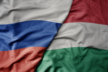 big waving realistic national colorful flag of russia and national flag of hungary .