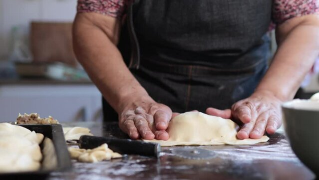 Culinary Tradition: Latin Elderly Woman Making Chilean Baked Beef Empanadas in her Home Kitchen