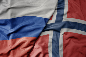 big waving realistic national colorful flag of russia and national flag of norway .