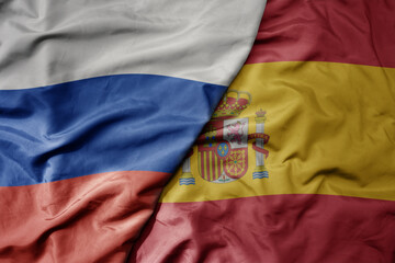 Fototapeta premium big waving realistic national colorful flag of russia and national flag of spain .