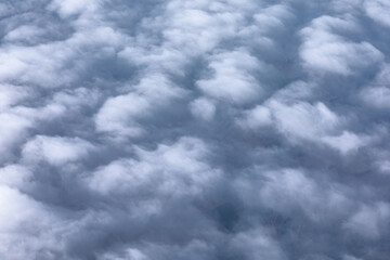 Clouds and sky as seen through window of an aircraft during flight . Grey cloudscape background