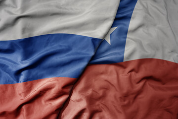big waving realistic national colorful flag of russia and national flag of chile .