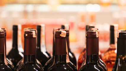 Alcohol bottles close up view. Tax increase on alcohol. Alcohol bottles on market shelf. Selective...