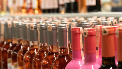 Alcohol bottles close up view. Tax increase on alcohol. Alcohol bottles on market shelf. Selective...