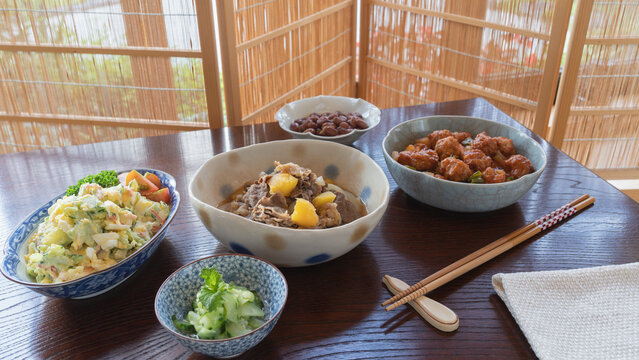 和食イメージ　菜箸とお惣菜｜ポテトサラダ・肉団子の甘酢あん・肉じゃが・金時豆・キュウリの酢の物