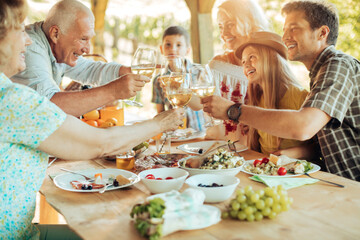 Multigenerational family enjoying a family lunch on a patio at a vineyard