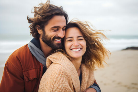 Joyful young couple, a man and woman, sharing a loving hug on a beach
