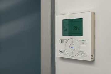 wall-mounted air-conditioning remote controller inside home or hotel, room temperature control panel