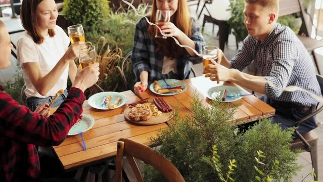 Young smiling people, cheerful friends meeting together in pub, drinking beer, having fun. Celebration. Concept of oktoberfest, traditional taste, friendship, leisure time, enjoyment