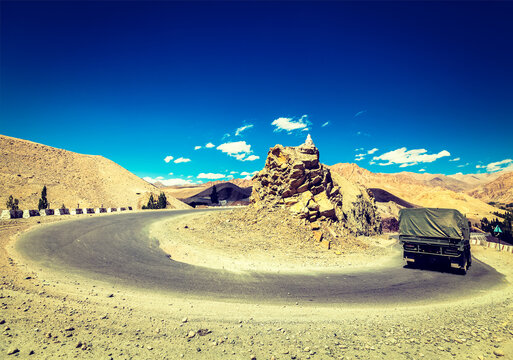 Vintage retro effect filtered hipster style travel image of Road in Himalayas with army truck. Ladakh, India