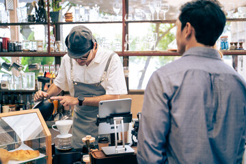 Asian attractive men receive hot coffee from waiter in coffee house. 