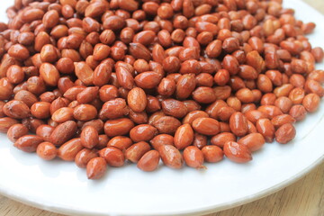 Fried peanuts in a white plate on the table

