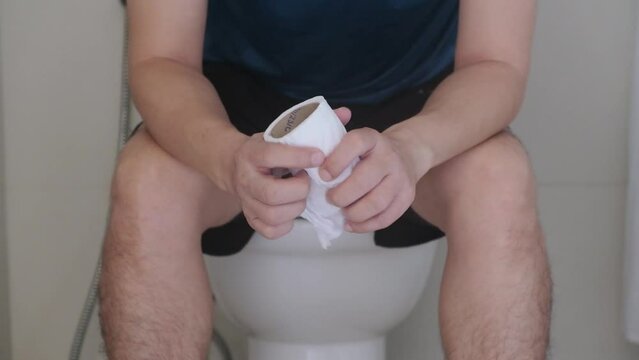 Man's hand, he holds a roll of toilet paper Going to the bathroom Toilet toilet background