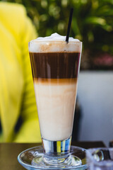 Large cup of coffee served on a table in a coffee shop.