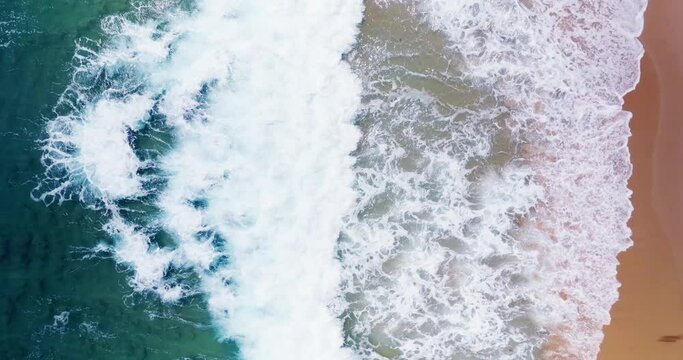 Coastal Phuket Thailand, as monsoon storms surpass high waves, top-down view aerial video, huge sea waves rolling into sandy beach at Andaman sea Filmed with high quality film cameras. DCI 4K ProRes