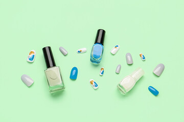 Press-on nails with polishes on green background