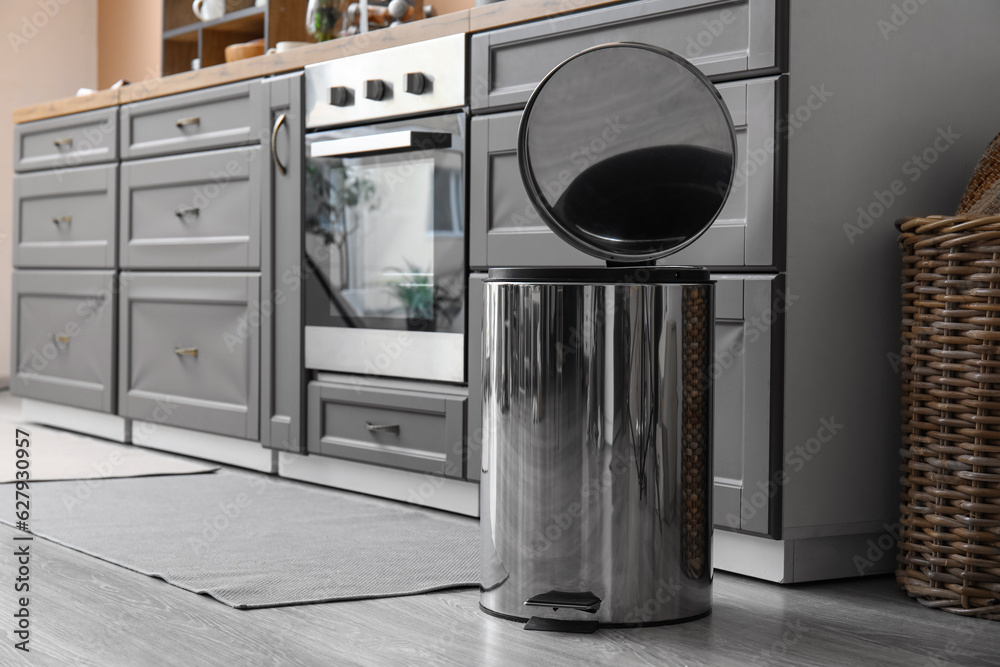 Sticker Opened metallic trash bin on floor in modern kitchen