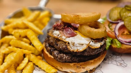 hamburger burger with ban french fries on table bacon egg onion