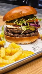 hamburger burger with ban french fries on table bacon egg onion
