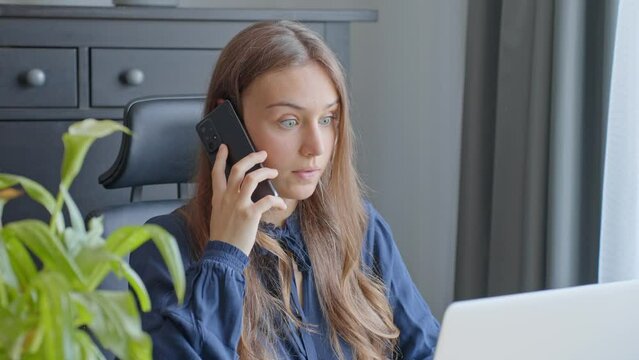 Young woman office worker on phone call shocked hearing about working news