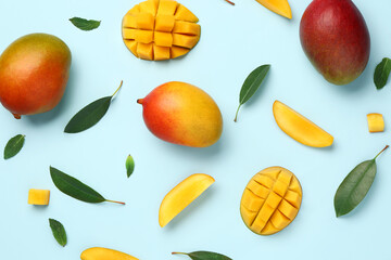 Fresh ripe mangoes on light blue background