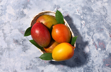Basket of fresh ripe mangoes on grunge background