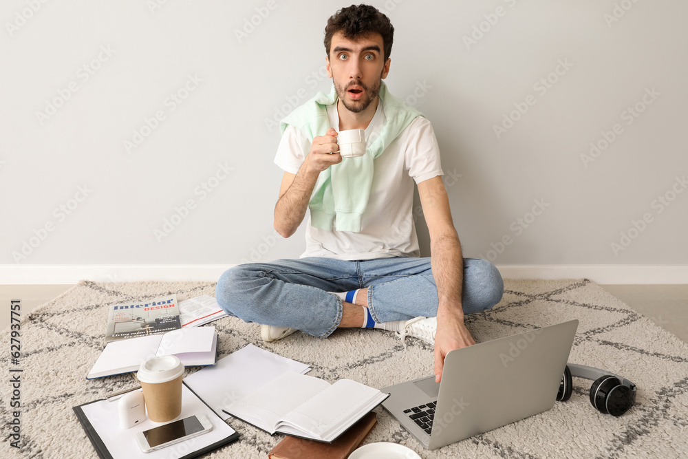 Sticker young man with cup of coffee and laptop working near light wall