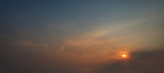 Evening sky with the orange sun sets the horizon ablaze with a warm and captivating glow.