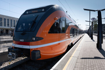 Modern passenger electric train arrives at the station in Tallinn. There is no one on the platform