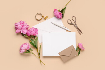 Composition with blank card, beautiful peony flowers, scissors and envelopes on color background