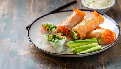 Vegan spring rolls with carrots, cucumber, green onions and rice noodles, selective focus