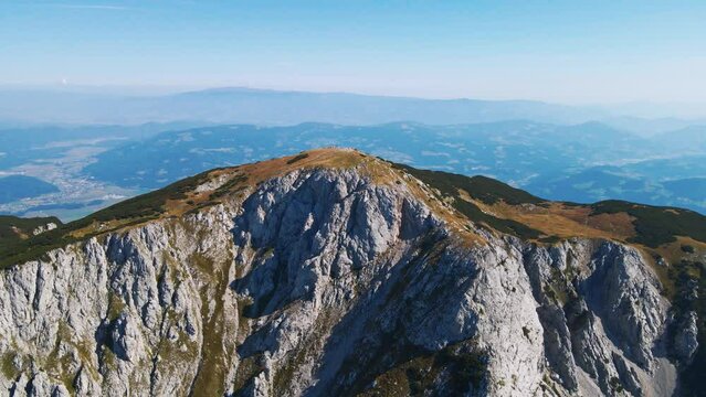 Stunning 4K drone footage of Saddle bellow Kordezeva Glava - Peca mountain in Karavanke mountain range. Beautiful Slovenian scenery of peaks of Kamnik-Savinja Alps in the background. Summer time.
