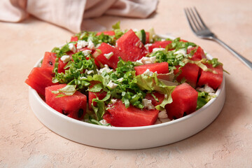 Plate of tasty watermelon salad on beige background