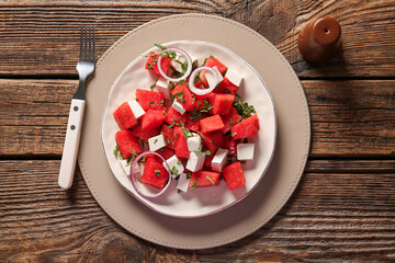 Plate of tasty watermelon salad on wooden background