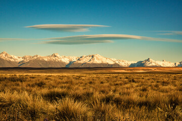 Snow covered  Southern Alps with Lenticular clouds taken from the rural landscape of the Tekapo to Twizel road