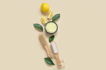 Bowl of lemon body scrub with massage brushes on beige background