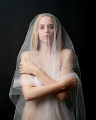 Full length portrait of beautiful blonde woman wearing white gown dress with flowing ghostly veiled...