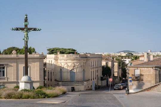 Cityscape view of landmark bronze calvary and ancient stone buildings on place Giral, Montpellier, France, on a bright summer morning