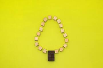 黄緑の背景の段がある樹木をモチーフにしたウッドキューブの木の形