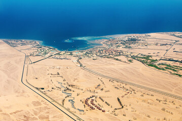 Aerial View of the Red Sea Coast in Hurghada, Egypt with many hotels bay out of airplane landing - 627948748